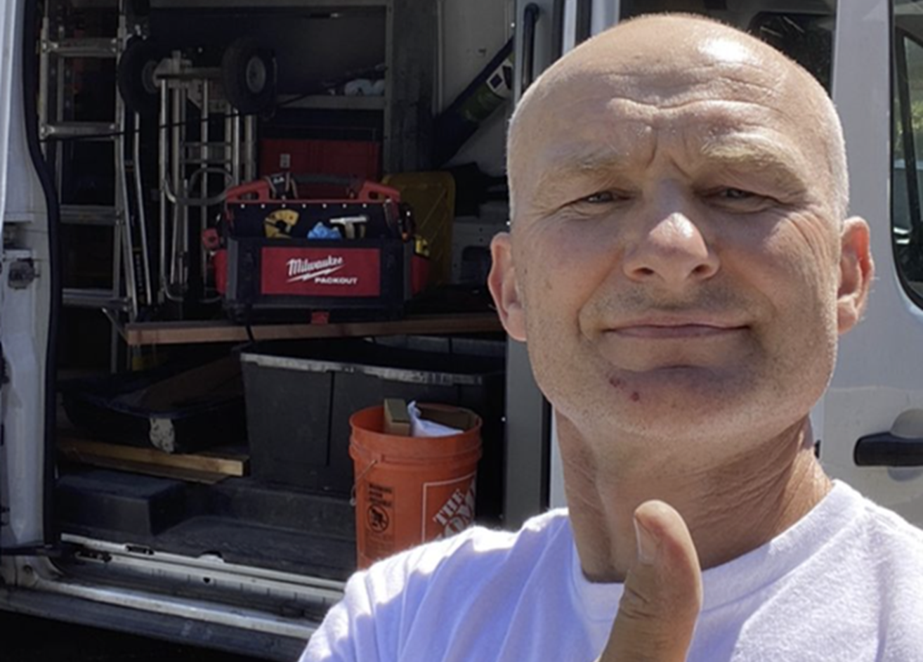 Artisan serrurier devant son véhicule d'intervention équipé, prêt à se déplacer